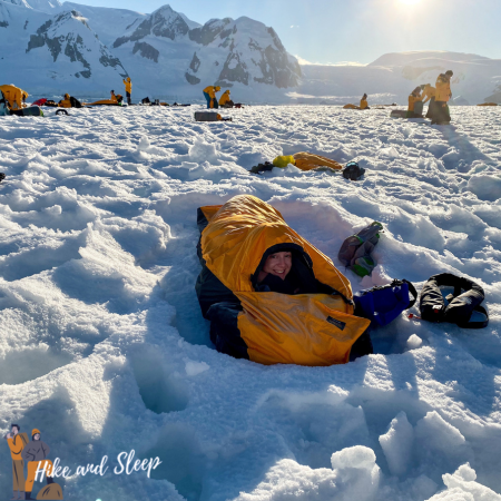person resting in a sleeping bag in the snow