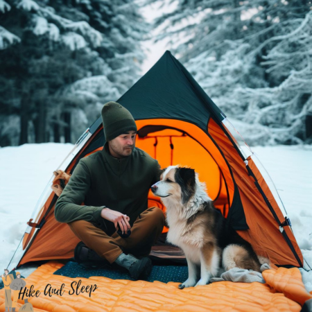 man camping with a dog on an insulated tent pad